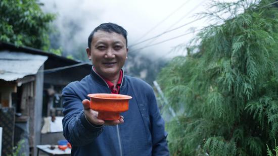  扎西巴珠展示他制作的木碗。新華網(wǎng) 旦增努布攝